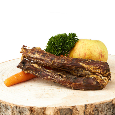 getrocknete Entenhälse auf Holzbrett mit Apfeldeko